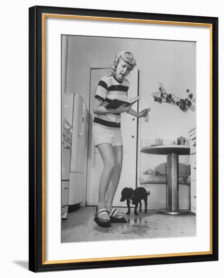 Woman Scrubbing Kitchen Floor with Brushes Attached to Her Feet-Allan Grant-Framed Photographic Print