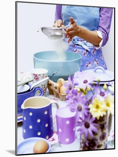 Woman Sieving Flour into a Bowl, Crockery & Eggs in Front-Linda Burgess-Mounted Photographic Print