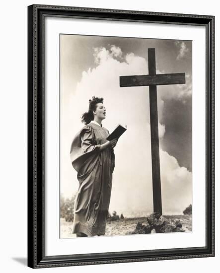 Woman Singing Hymns by a Large Wooden Cross on a Hill-null-Framed Photo