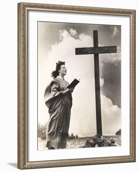 Woman Singing Hymns by a Large Wooden Cross on a Hill-null-Framed Photo