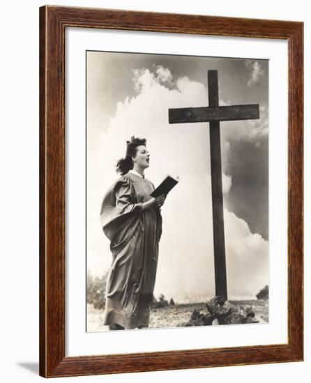 Woman Singing Hymns by a Large Wooden Cross on a Hill-null-Framed Photo