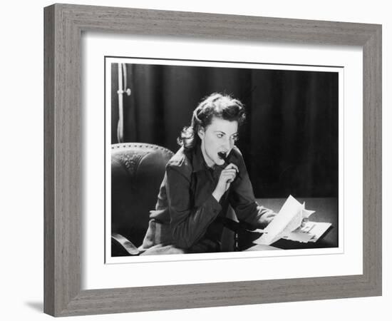 Woman Sits with Her Pen in Her Mouth Whilst Thinking About What She Should Write in Her Letter-null-Framed Art Print