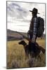 Woman Stands Next To Her Hunting Dog Looking Out Into Montana's Vast Landscape-Hannah Dewey-Mounted Photographic Print