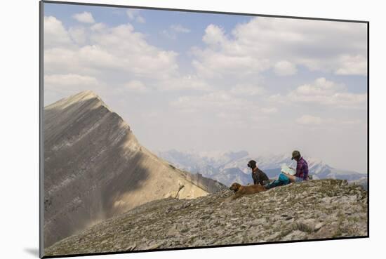 Woman Takes A Break From Hiking To Read A Map In Montana's Bob Marshall Wilderness-Hannah Dewey-Mounted Photographic Print