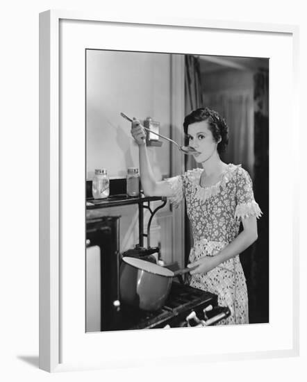 Woman Tasting Food Cooking on Stove-null-Framed Photo