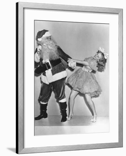Woman Trying to Dance with Santa Claus-null-Framed Photo