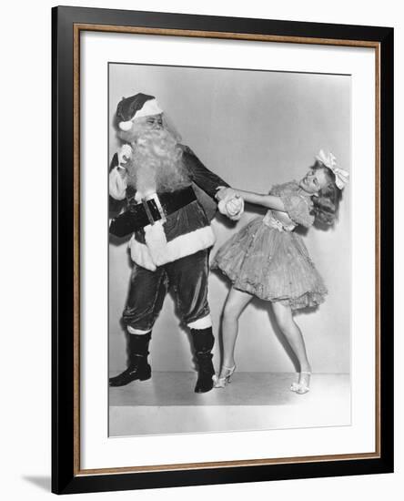 Woman Trying to Dance with Santa Claus-null-Framed Photo