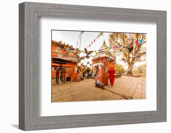 Woman walking and praying with pigeons at the hilltop temple, Bhaktapur, Kathmandu Valley, Nepal, A-Laura Grier-Framed Photographic Print