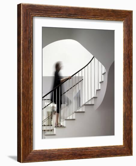 Woman walking up staircase holding handrail-John Edward Linden-Framed Photo