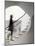 Woman walking up staircase holding handrail-John Edward Linden-Mounted Photo