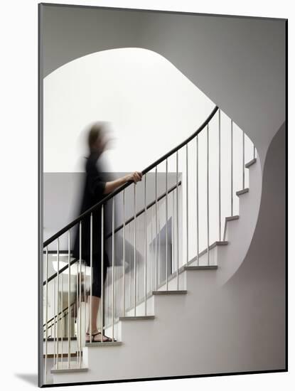 Woman walking up staircase holding handrail-John Edward Linden-Mounted Photo