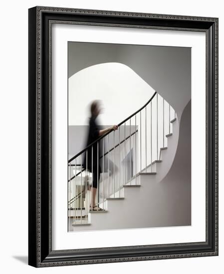 Woman walking up staircase holding handrail-John Edward Linden-Framed Photo