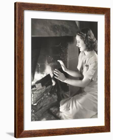 Woman Warming Her Hands by the Fireplace-null-Framed Photo