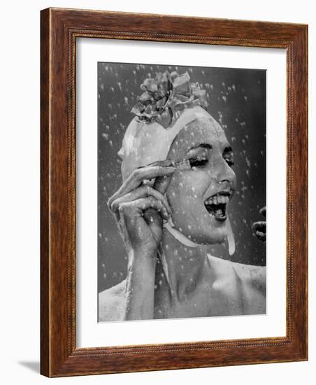 Woman Wearing Flowered Bathing Cap and Applying Mascara as Water Showers Around Her-Gjon Mili-Framed Photographic Print