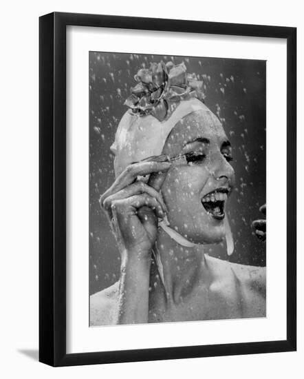 Woman Wearing Flowered Bathing Cap and Applying Mascara as Water Showers Around Her-Gjon Mili-Framed Photographic Print