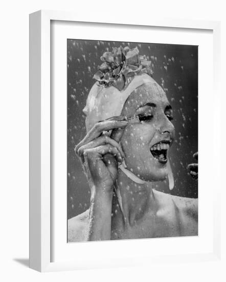 Woman Wearing Flowered Bathing Cap and Applying Mascara as Water Showers Around Her-Gjon Mili-Framed Photographic Print