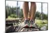 Woman Wearing Running Shoes Stands On A Log In Idaho's Payette National Forest During Summer-Hannah Dewey-Mounted Photographic Print