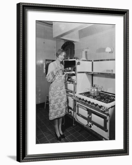 Woman with Large Stove Holding Pan-null-Framed Photo