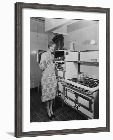 Woman with Large Stove Holding Pan-null-Framed Photo