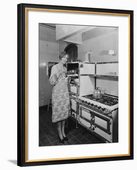 Woman with Large Stove Holding Pan-null-Framed Photo