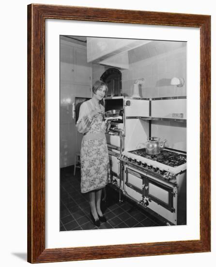 Woman with Large Stove Holding Pan-null-Framed Photo