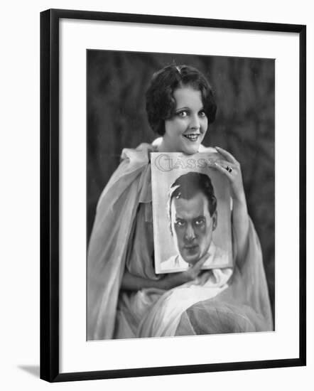 Woman with Portrait of Man on Magazine Cover-null-Framed Photo