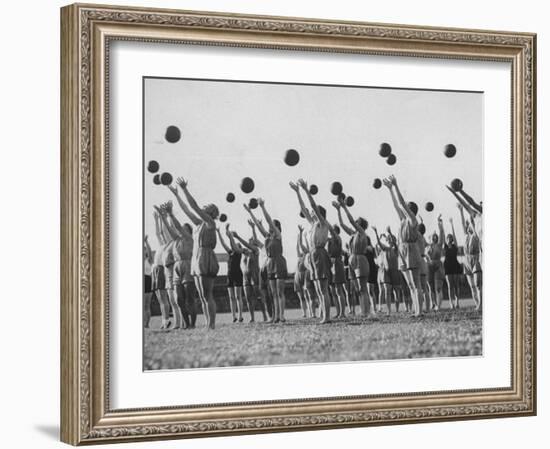 Women's Gym Class with Rows of Women Throwing Balls Into Air in Unison-null-Framed Photographic Print