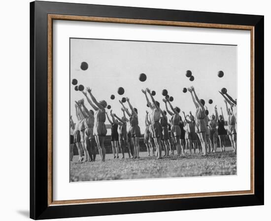 Women's Gym Class with Rows of Women Throwing Balls Into Air in Unison-null-Framed Photographic Print