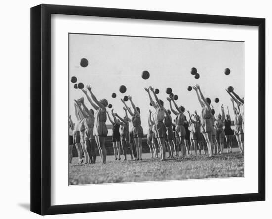 Women's Gym Class with Rows of Women Throwing Balls Into Air in Unison-null-Framed Photographic Print