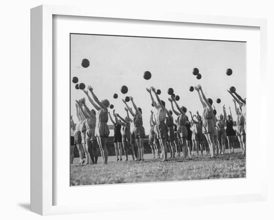 Women's Gym Class with Rows of Women Throwing Balls Into Air in Unison-null-Framed Photographic Print