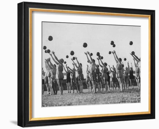 Women's Gym Class with Rows of Women Throwing Balls Into Air in Unison-null-Framed Photographic Print