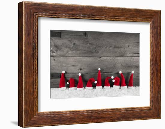 Wooden Christmas Background with Red Santa Hats for a Festive Frame or Card.-Imagesbavaria-Framed Premium Photographic Print