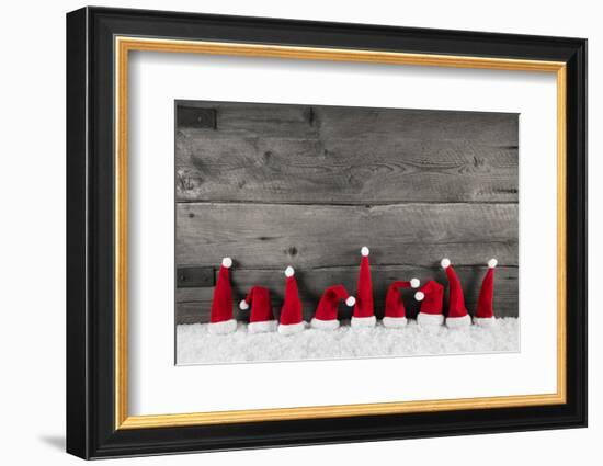 Wooden Christmas Background with Red Santa Hats for a Festive Frame or Card.-Imagesbavaria-Framed Premium Photographic Print