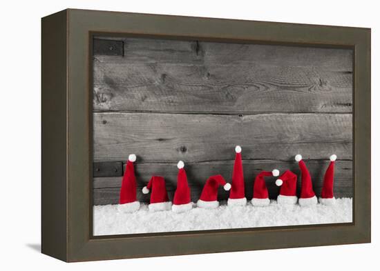 Wooden Christmas Background with Red Santa Hats for a Festive Frame or Card.-Imagesbavaria-Framed Premier Image Canvas