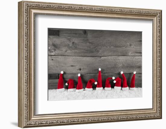 Wooden Christmas Background with Red Santa Hats for a Festive Frame or Card.-Imagesbavaria-Framed Photographic Print