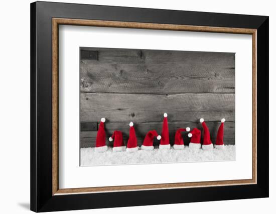 Wooden Christmas Background with Red Santa Hats for a Festive Frame or Card.-Imagesbavaria-Framed Photographic Print