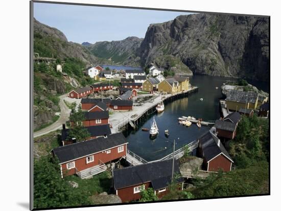 Wooden Red Houses on Stilts Over Water at the Fishing Village of Nusfjord, Lofoten Islands, Norway-Tony Waltham-Mounted Photographic Print