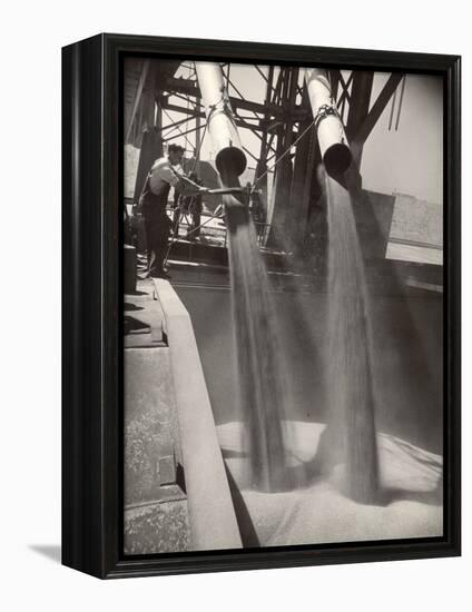 Workers Guiding Granary Filling Spouts as They Pour Tons of Wheat into River Barge for Shipment-Margaret Bourke-White-Framed Premier Image Canvas