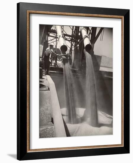 Workers Guiding Granary Filling Spouts as They Pour Tons of Wheat into River Barge for Shipment-Margaret Bourke-White-Framed Photographic Print