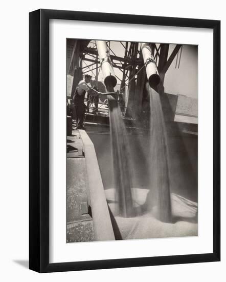 Workers Guiding Granary Filling Spouts as They Pour Tons of Wheat into River Barge for Shipment-Margaret Bourke-White-Framed Photographic Print