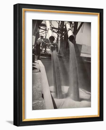 Workers Guiding Granary Filling Spouts as They Pour Tons of Wheat into River Barge for Shipment-Margaret Bourke-White-Framed Photographic Print