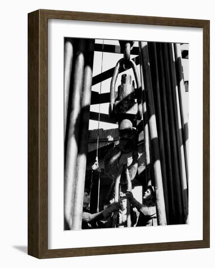 Workers Lower Pipe into Oil Well Inside Rig in a Texaco Oil Field-Margaret Bourke-White-Framed Photographic Print