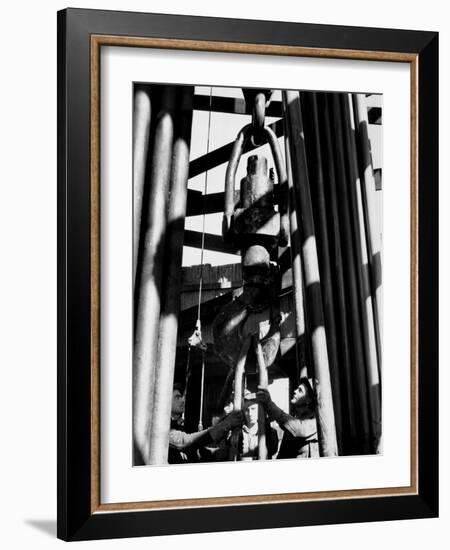 Workers Lower Pipe into Oil Well Inside Rig in a Texaco Oil Field-Margaret Bourke-White-Framed Photographic Print