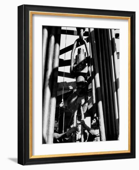 Workers Lower Pipe into Oil Well Inside Rig in a Texaco Oil Field-Margaret Bourke-White-Framed Photographic Print