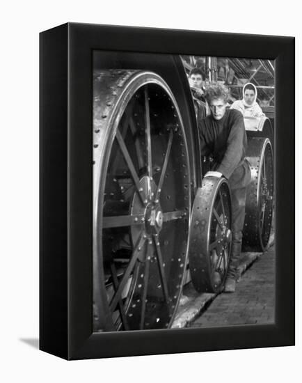 Workers Standing Amidst Large Metal Wheel Frames on Tractorstroi Tractor Factory Assembly Line-Margaret Bourke-White-Framed Premier Image Canvas