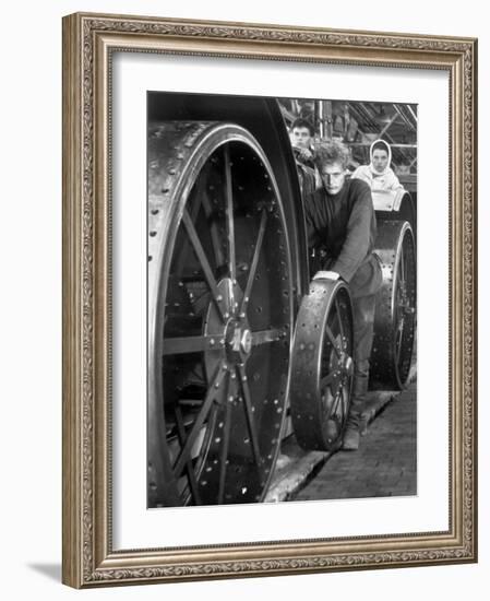 Workers Standing Amidst Large Metal Wheel Frames on Tractorstroi Tractor Factory Assembly Line-Margaret Bourke-White-Framed Photographic Print