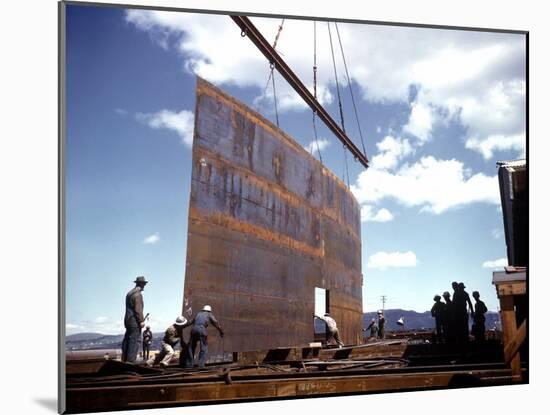 Workers Watching as Steel Beam is Raised High Above During Sub Assembling of Ship at Shipyard-Hansel Mieth-Mounted Photographic Print