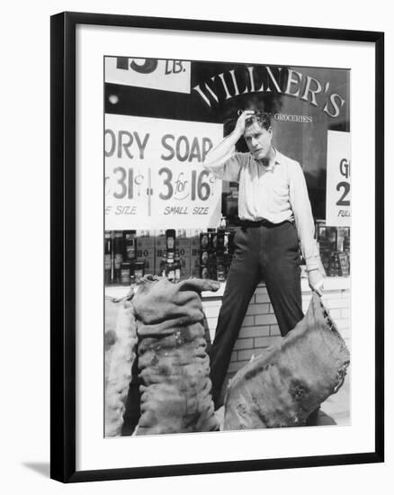 Worried Man Holding Sack-null-Framed Photo