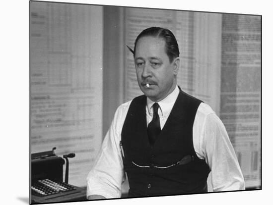 Writer Robert Benchley, Sitting at His Desk with a Small Wade of Paper in His Mouth-Bernard Hoffman-Mounted Premium Photographic Print