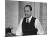 Writer Robert Benchley, Sitting at His Desk with a Small Wade of Paper in His Mouth-Bernard Hoffman-Mounted Premium Photographic Print